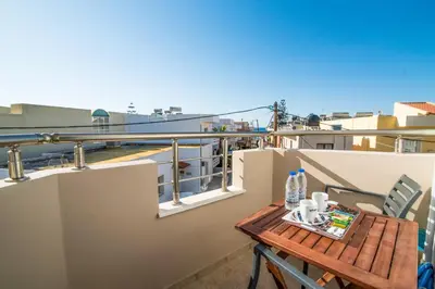 a small table on a balcony with a view at Kristina Stelios Apartment in Plataniás
