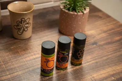 three bottles of sauce on a wooden table with a plant at Harmony Apartment in Chania in Chania Town