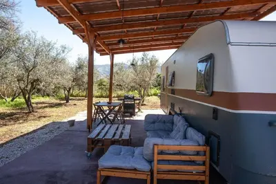 a covered porch of a rv with chairs and a table at Onar Camper in Liyidhés