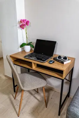 a laptop computer sitting on a wooden desk with a chair at Central apt. with parking - 3 min from old port in Chania Town