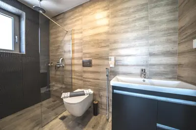 a bathroom with a toilet and a sink and a shower at Nafsika Xenia - Alkinoos Villa in Plátanos