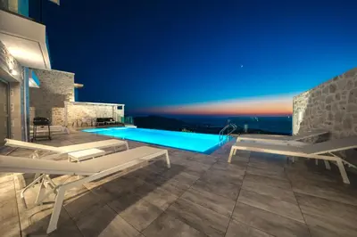 a villa with a swimming pool at night at Nafsika Xenia - Alkinoos Villa in Plátanos