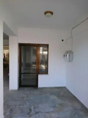 a white room with a door and a stone floor at Sunny family apartment in Chania close to the sea in Chania Town