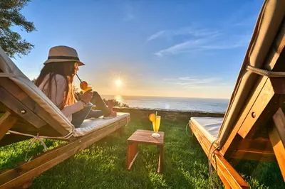 a woman sitting in a hammock watching the ocean at Metochi Seaview Holiday House in Ayía Paraskeví