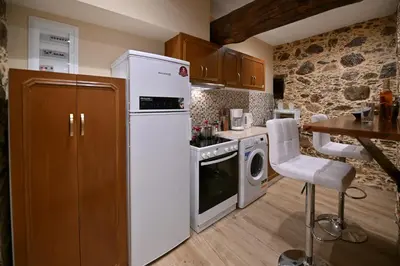 a kitchen with a white refrigerator and a table at Metochi Seaview Holiday House in Ayía Paraskeví