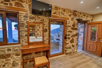a stone room with a vanity and a mirror at Metochi Seaview Holiday House in Ayía Paraskeví