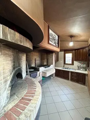 a large kitchen with a brick fireplace in a room at Villa Recluso-3 bd luxury country villa, huge heated pool with hydromassage, individual bbq & large yard, mountain view in Maláxa
