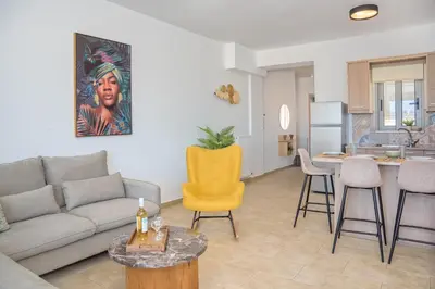 a living room with a couch and a table and a kitchen at Casa Kamara in Kounoupidhianá