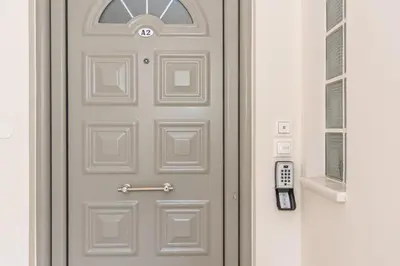 a grey door with a window and a remote control at Casa Kamara in Kounoupidhianá