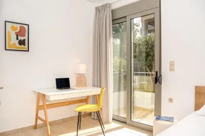 a bedroom with a desk and a bed with a laptop at Casa Kamara in Kounoupidhianá