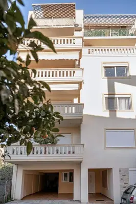 a tall white building with a balcony on it at Marita Luxury Apartment with parking space in Chania Town