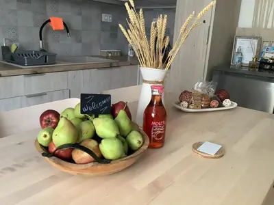 a bowl of apples on a table with a bottle of sauce at Granny's Nest in Kalyves
