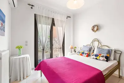 a bedroom with a pink bed and a window at Private apartment in Kalamaki, Chania in Galatás