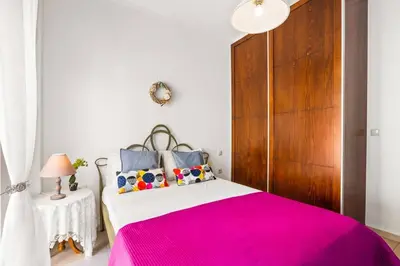 a bedroom with a pink bed and a wooden cabinet at Private apartment in Kalamaki, Chania in Galatás