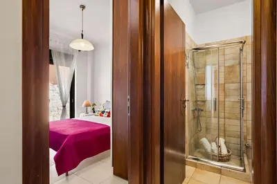 a bathroom with a walk in shower next to a bedroom at Private apartment in Kalamaki, Chania in Galatás