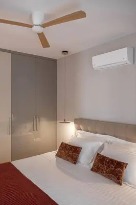 a bedroom with a bed with a ceiling fan at Angelo Luxury Apartment in Chania Town
