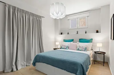 a bedroom with a bed with a blue blanket at Nisos apartments, Chania center in Chania Town