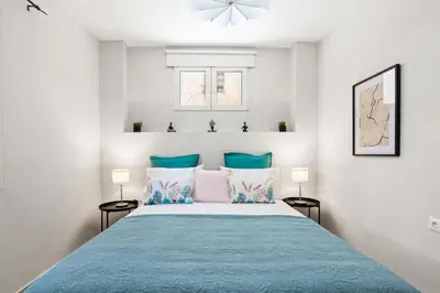 a bedroom with a large bed with blue pillows at Nisos apartments, Chania center in Chania Town