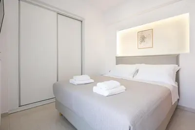 a white bedroom with two towels on a bed at -Superior Maisonette Jacuzzi & Private Parking - Koum Kapi Mare Seaside in Chania Town