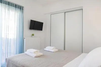 a white bedroom with two towels on a bed at -Superior Maisonette Jacuzzi & Private Parking - Koum Kapi Mare Seaside in Chania Town