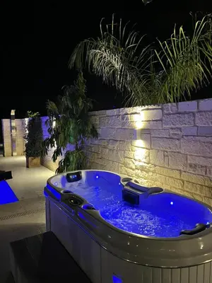 a jacuzzi tub in a backyard at night at Amare suite in Perivólia