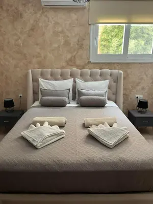 a large bed with two towels and pillows on it at Amare suite in Perivólia