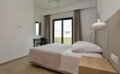 a bedroom with a large bed and a window at Rosemary Apartments in Palaiochóra