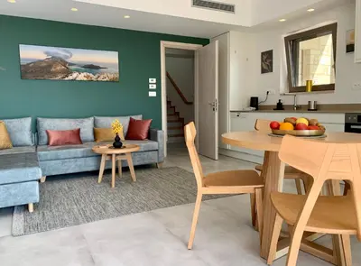 a living room with a blue couch and a table at Christos Place-Paleochora in Palaiochóra