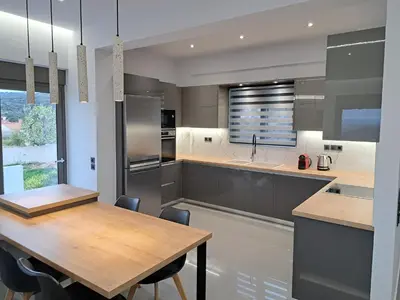 a kitchen with a wooden table and a kitchen island at Christine luxury villa in Kolymvari