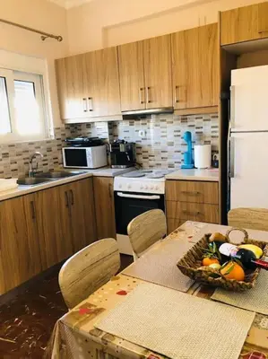a kitchen with a table with a bowl of fruit on it at Ariadni's apartment 2 in Chania Town