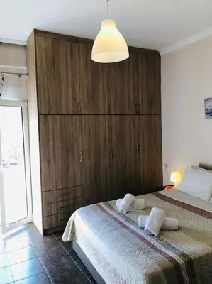 a bedroom with a bed with a large wooden cabinet at Ariadni's apartment 2 in Chania Town