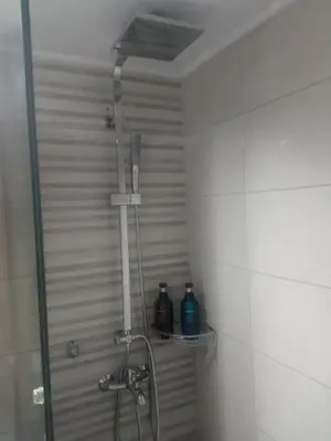 a shower in a bathroom with two bottles on a shelf at Capt73134 in Chania Town