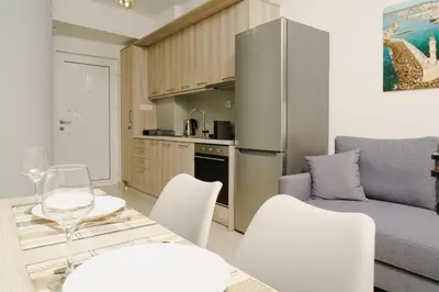 a kitchen and a living room with a table and chairs at EDEL Luxury Apartments in Chania Town