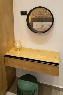 a mirror on a wall next to a table with a green stool at Casa Dionysia - New Lux 2Br with Jacuzzi near Maleme Beach in Maleme