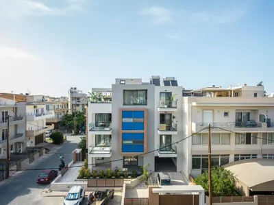 an apartment building with blue windows and a street at Disegno Residences in Chania Town
