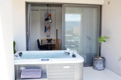a bath tub in a bathroom with a window at Disegno Residences in Chania Town