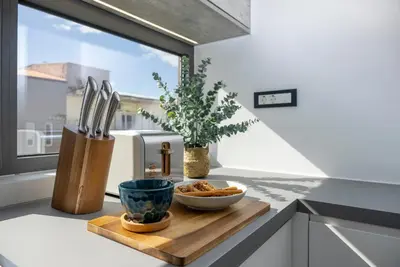 a kitchen counter with a bowl of food on a cutting board at Disegno Residences in Chania Town