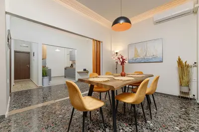 a dining room with a wooden table and chairs at Dk central apartment in the heart of the city in Chania Town