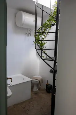a bathroom with a toilet and a spiral staircase at Casa Bollani - Old Town Chania House in Chania Town