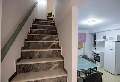 a staircase in a house with a kitchen and a table at Casa Bollani - Old Town Chania House in Chania Town