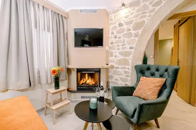 a living room with a couch and a fireplace at Alonion Apartments in Yerakianá
