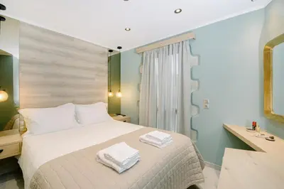 a bedroom with a bed with two towels on it at Alonion Apartments in Yerakianá