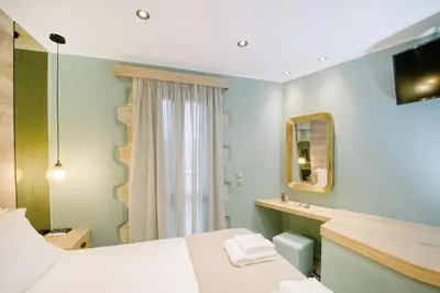 a bedroom with a bed and a mirror at Alonion Apartments in Yerakianá