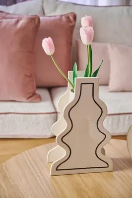 a white vase with pink flowers in it on a table at Elyn House in Chania Town
