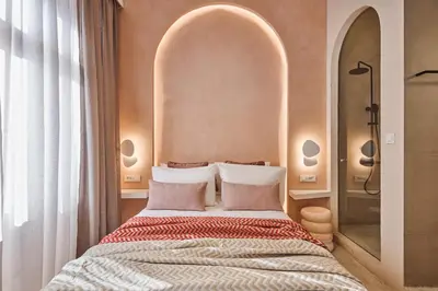 a bedroom with a large bed with an arched headboard at Elyn House in Chania Town