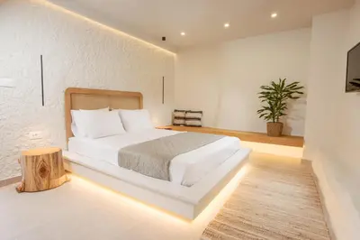 a bedroom with a white bed and a tree stump in it at Elirion Luxury Home in Kamária