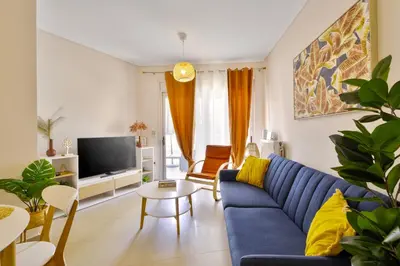 a living room with a blue couch and a tv at Lazaretta apartment 2 in Chania Town