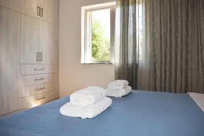 a bedroom with a blue bed with towels on it at Agrabeli Cot Not Just a Stay A Unique Experience in Plátanos