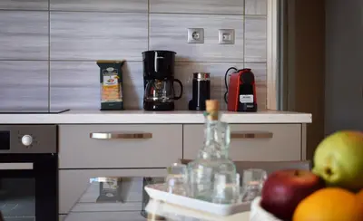 a kitchen counter with a coffee maker and fruit on it at Agrabeli Cot Not Just a Stay A Unique Experience in Plátanos