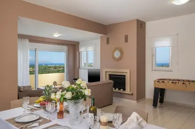 a dining room with a table with flowers on it at Olive Tree Villa in Chania Town